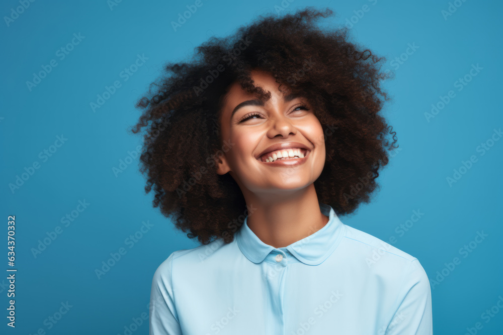 Radiant Smiles: Joyful African American Woman Poses in Vibrant Blue Studio Setting Radiant Smiles: Joyful African American Woman Poses in Vibrant Blue Studio Setting