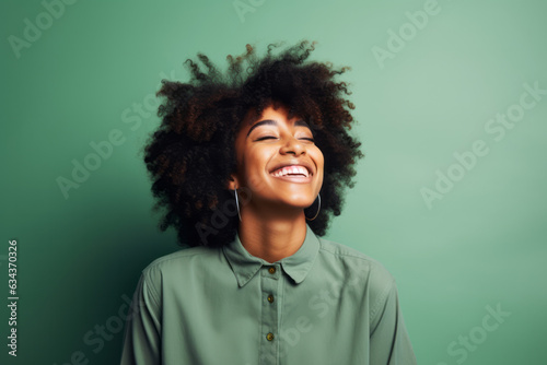 Radiant Smiles: Joyful African American Woman Poses on Vibrant Green Studio Background