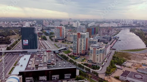 A new modern colored residential complex next to the river. Air view of luxury houses with developed transport infrastructure. surface metro between buildings