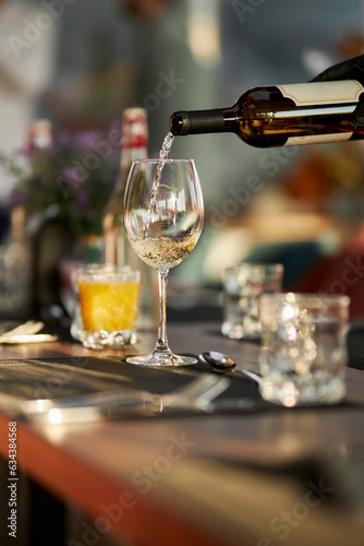 The waiter pours white wine into a glass. Soft focus. luxury living concept. Restaurant.  © Alenka