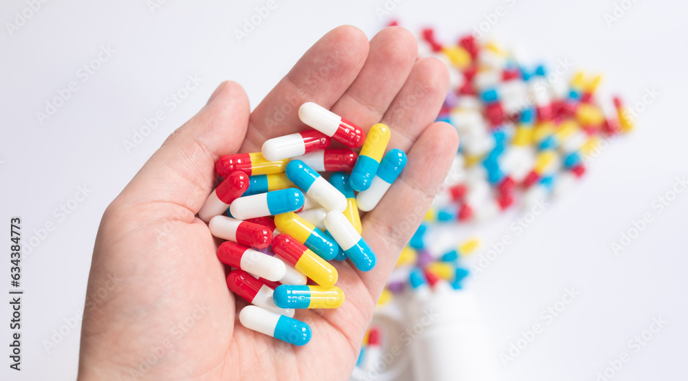 Close up hand holding medicine pills on white table background. Close up hand holding medicine pills on white table background.