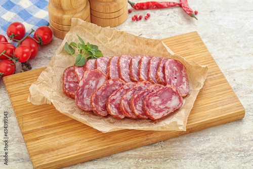 Sliced salami sausages over board