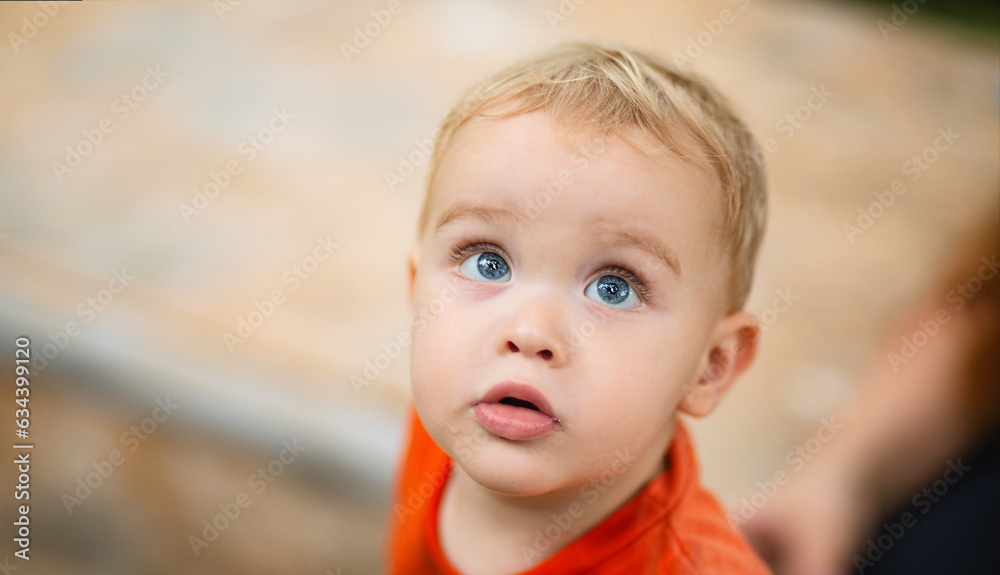 portrait of small boy on background of sandbox in the yard, close-up baby face looking up portrait of small boy on background of sandbox in the yard, close-up baby face looking up