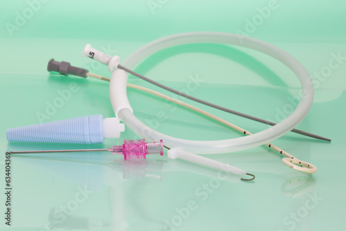 Pleural drainage set with pink percutaneous entry needle, Seldinger guidewire, Pigtail Catheter on light green background. Drainage of air or fluid from the pleural space photo
