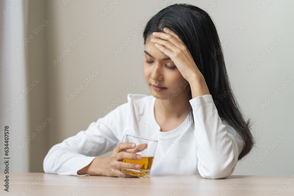 Alcoholism drunk, sad asian young woman fell asleep hand holding glass of alcohol or whiskey, alone depressed alone female drink booze. Treatment of alcohol addiction, suffer abuse problem alcoholism. Alcoholism drunk, sad asian young woman fell asleep hand holding glass of alcohol or whiskey, alone depressed alone female drink booze. Treatment of alcohol addiction, suffer abuse problem alcoholism.