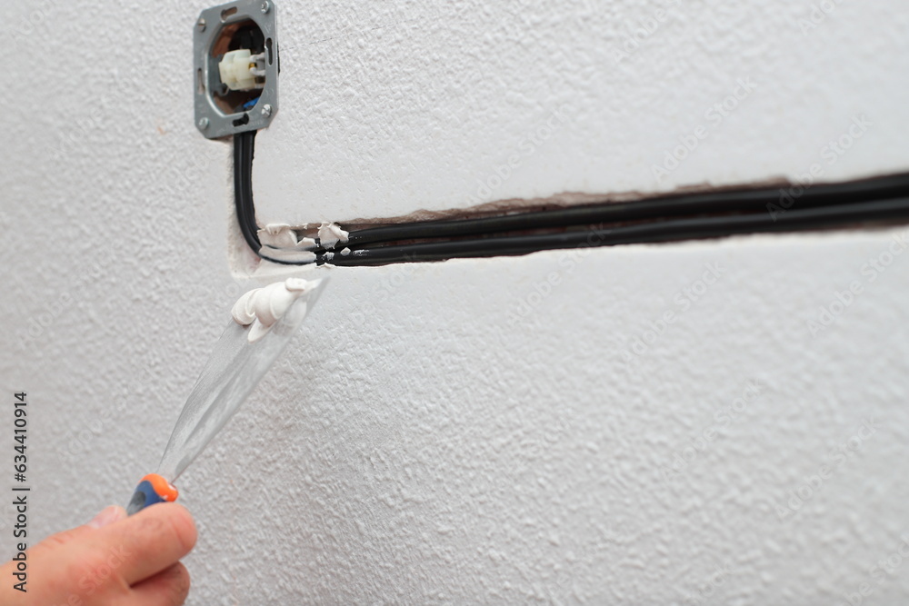 Home renovation, plastering plug wires in the wall, new made electricity wire covered by cement, house rapair Home renovation, plastering plug wires in the wall, new made electricity wire covered by cement, house rapair