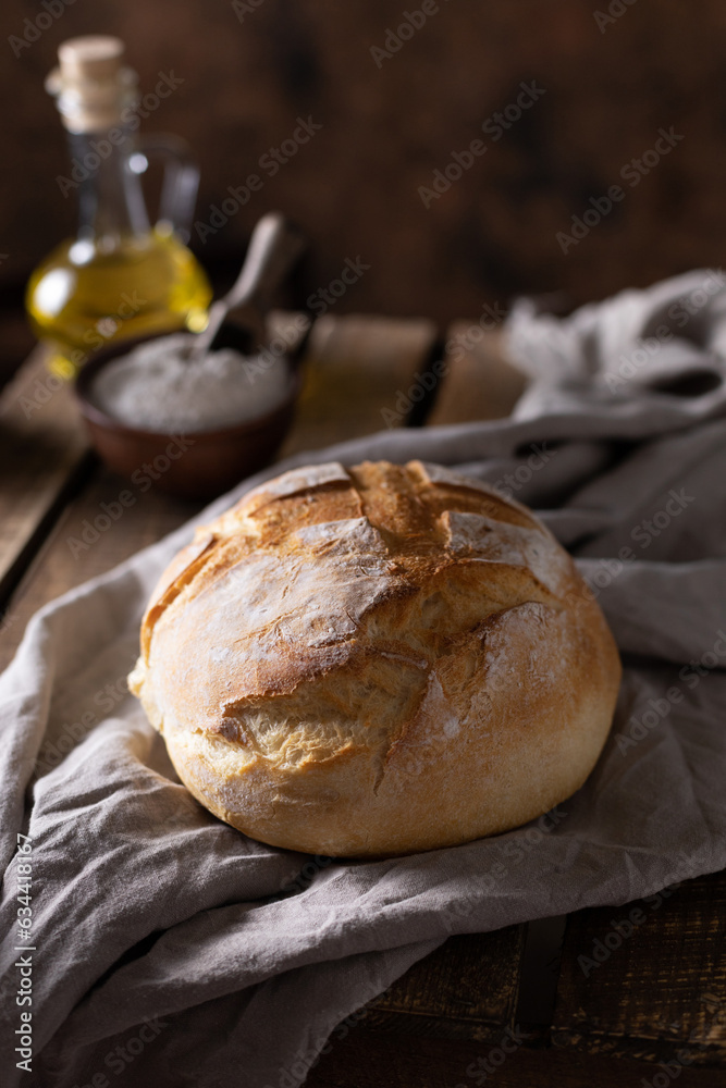 Fresh bread and table cloth on wooden table. Bakery still life and bread at wood tabletop