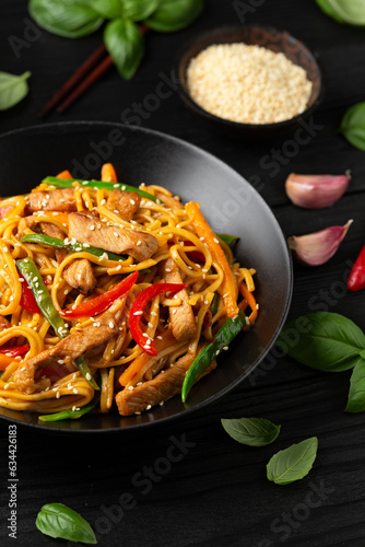 Stir fry chow mein noodles with pork and vegetable in black bowl. asian style food