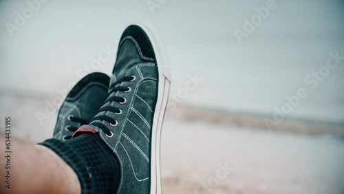 Man wearing sneakers on the seaside, close-up photo