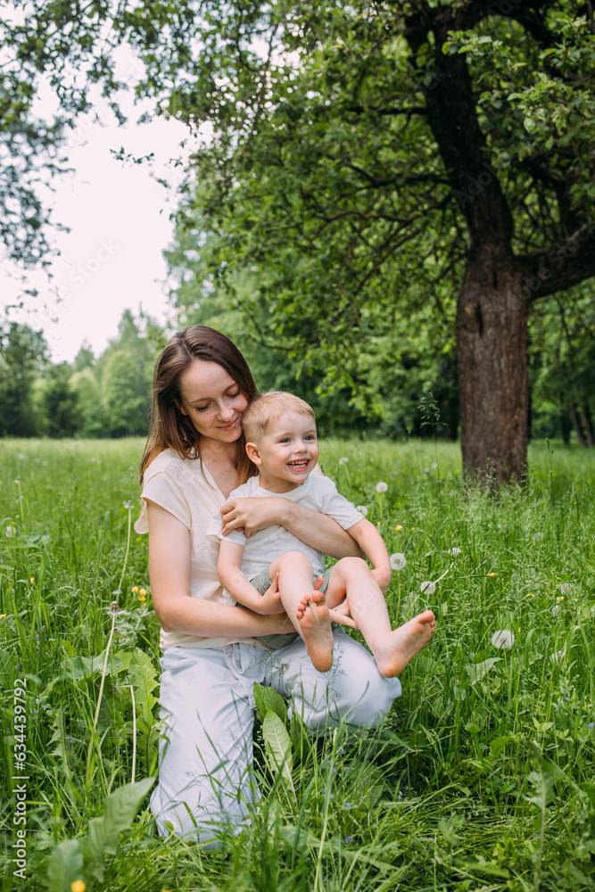 Young woman mom and son play in nature, spend time together and have fun Young woman mom and son play in nature, spend time together and have fun