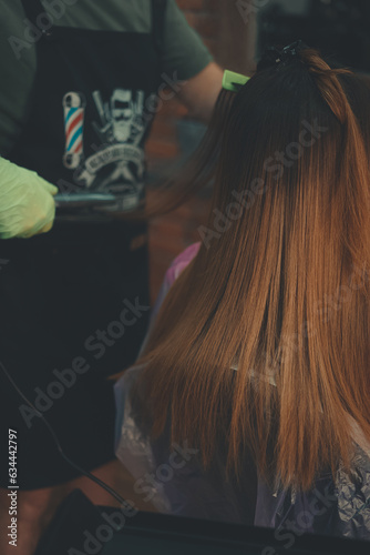 Hairstylist trimming hair of the customer in a beauty salon