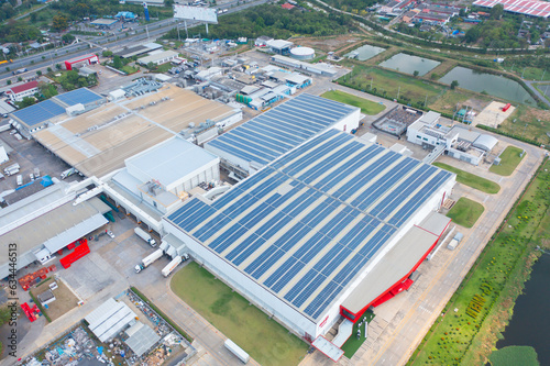 Aerial view of solar panels or solar cells on the roof of factory building rooftop. Power plant, renewable clean energy source. Eco technology for electric power in industry. © tampatra