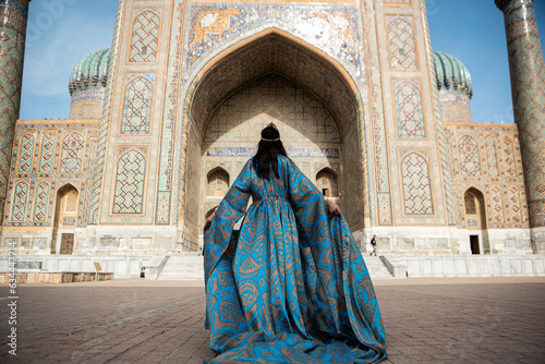 Uzbek woman in traditional dress in Registan square Samarkand, Uzbekistan photo