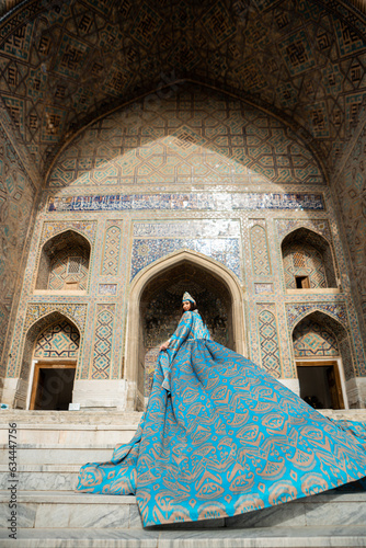 Uzbek woman in traditional dress in Registan square Samarkand, Uzbekistan photo