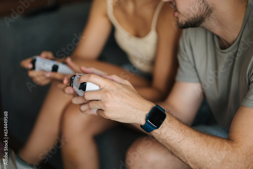 Middle selection of couple using video game joysticks gamepad and playing