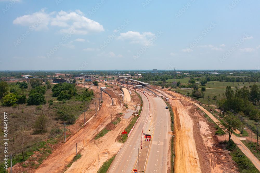 Aerial view of construction tractor car, bulldozer, or backhoe digging road or street in traffic transportation and agriculture concept. Engine working in urban city town.