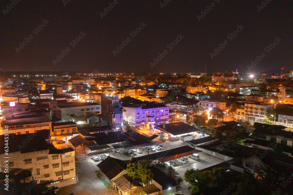 Aerial view of residential neighborhood roofs. Urban housing development from above. Top view. Real estate in Nakhon Phanom province city, Thailand. Property real estate at night.
