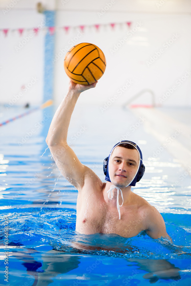 Water polo training. Young sportsman plays water polo in the pool.