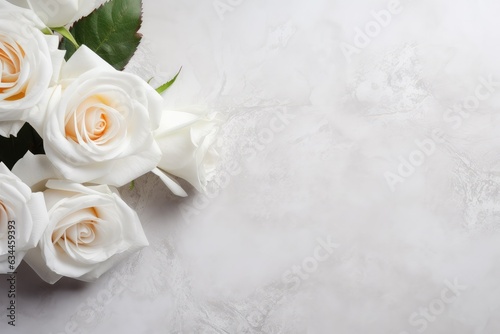 beautiful white roses and green leaves laying on marble background