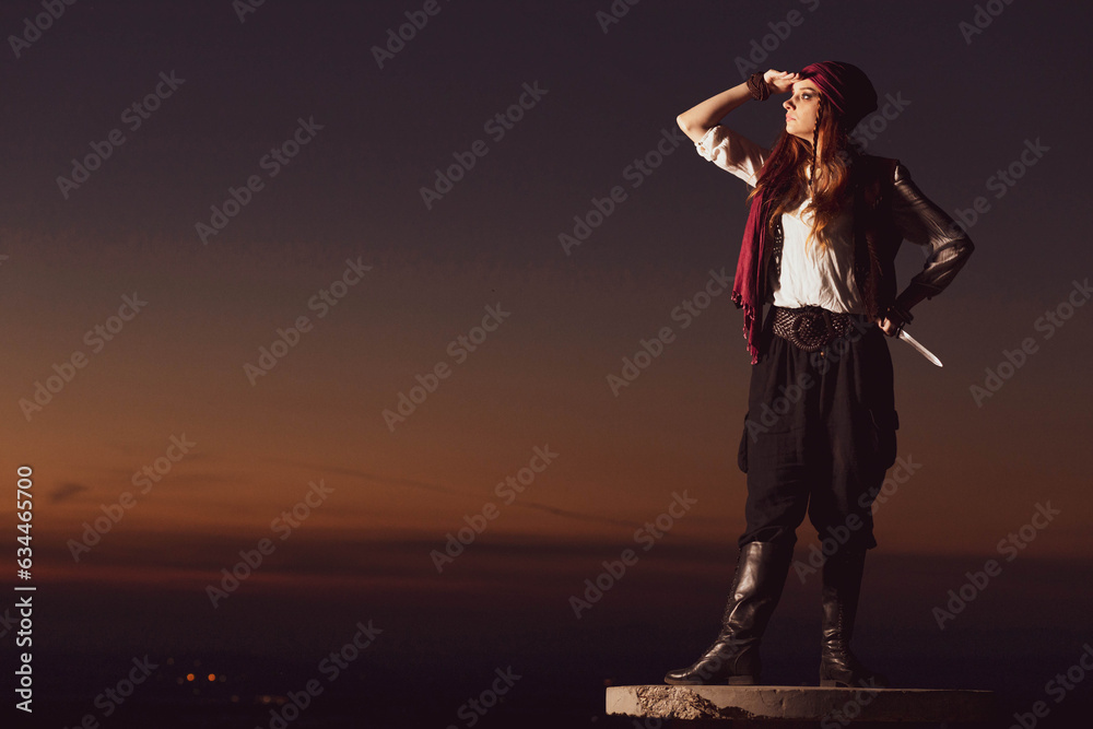 Fototapeta premium Outdoor portrait of young female in pirate costume, observing