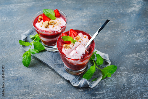 Traditionelle gefrorene Erdbeersuppe mit Erdbeereis und Crumbles serviert als Nahaufnahme auf einem grauen Stein Design Tablett mit Textfreiraum photo