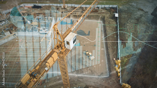 Yellow crane in construction site with graphics for production trend and control of workers team. Potential investiment income calculator. Aerial  photo