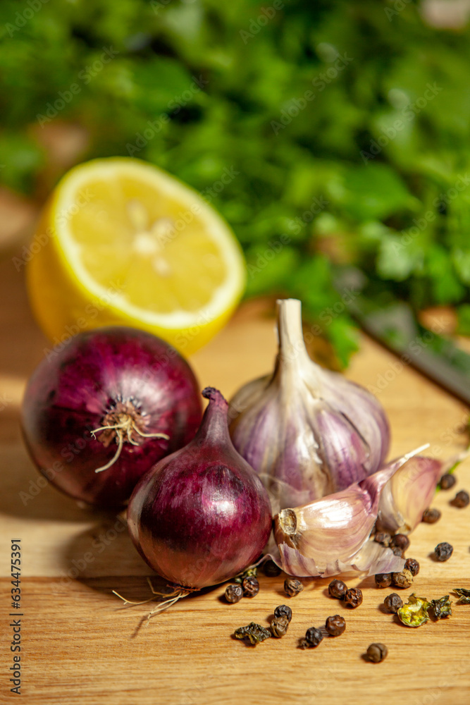 All-purpose seasoning for meat, fish or vegetables. Onion, garlic, pepper and lemon on greens background. Cooking healthy food.
