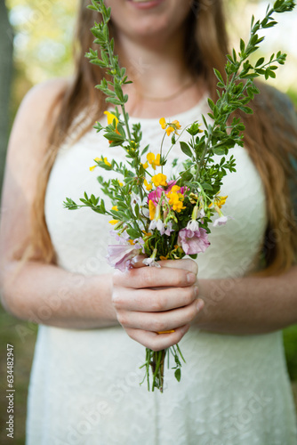 smiling young womAN with wild flowers