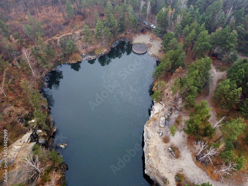 Picturesque aerial view of landscape with emerald lake and rocks in the middle of a coniferous autumn forest in Korostyshiv granite quarry, Zhytomyr district, northern Ukraine. Zhytomyr canyon photo