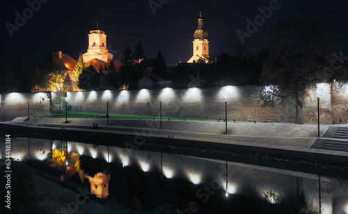 Night view of illuminated Episcopal Castle on riverside of Raba, Gyor, Hungary