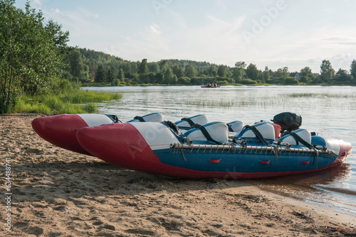 inflatable raft-catamaran for whitewater sports is moored on the river bank