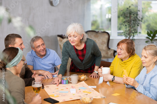 Older men and women playing board game together