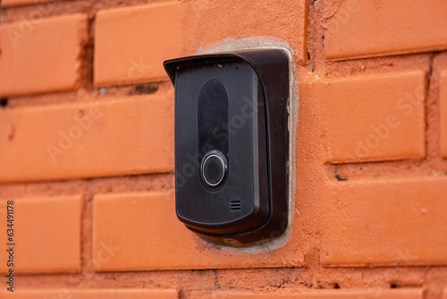 black intercom device on a brick wall