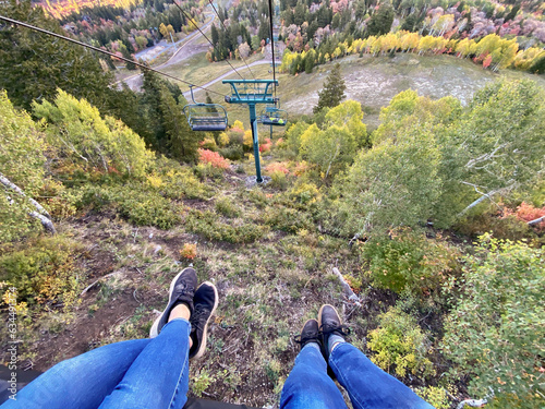 Personal perspective view of two women's legs outstretched on a ski lift, Sundance, Utah, USA photo