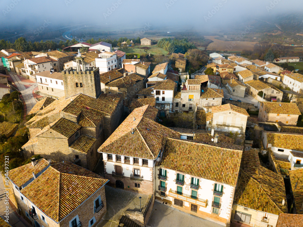 View from drone of roofs of houses in traditional village of Liedena in foggy morning, Navarre, Spain