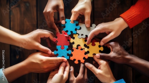 Diverse hands holding puzzle pieces that fit together to form a larger puzzle, depicting the idea that unique skills combine to solve complex challenges photo