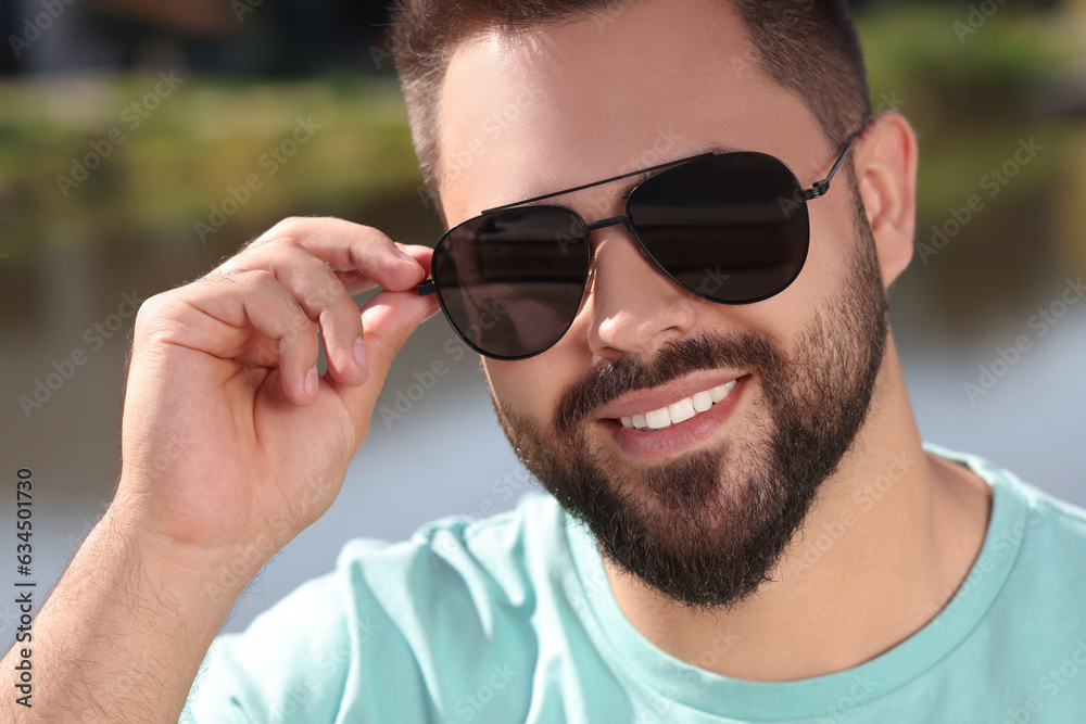 Handsome smiling man in sunglasses outdoors on sunny day Handsome smiling man in sunglasses outdoors on sunny day