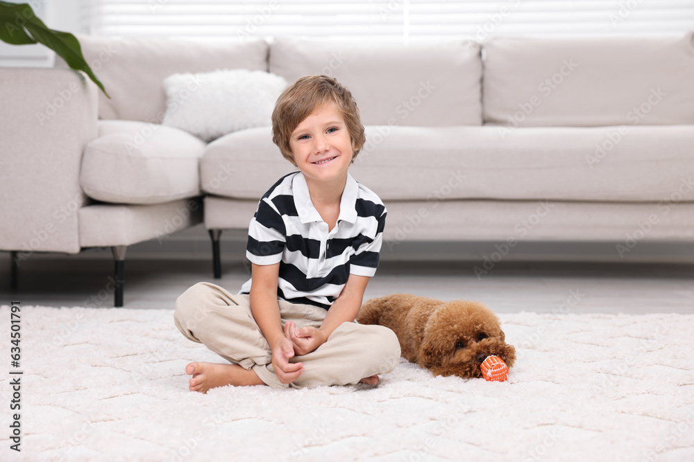 Little child and cute puppy on carpet at home. Lovely pet Little child and cute puppy on carpet at home. Lovely pet