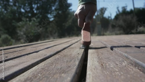 Deck maintenance. Hand brushing a wooden durface photo