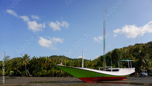 fishing boat parking in beautiful beach with clouds, bawean island, indonesia. photo