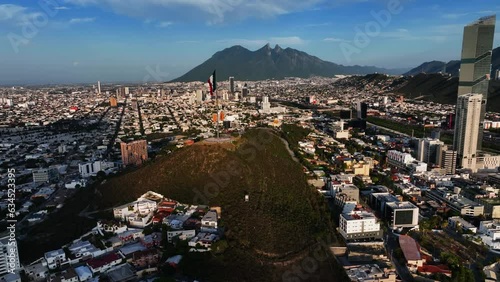 Drone shot circling a Mexican flag on top of the Bishopric Hill, in sunny Monterrey, Mexico photo