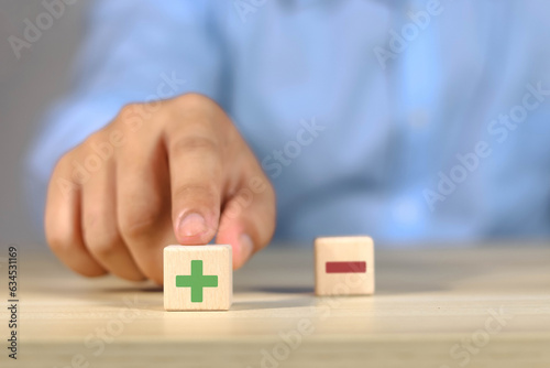 Foto Wooden blocks showing plus and minus signs