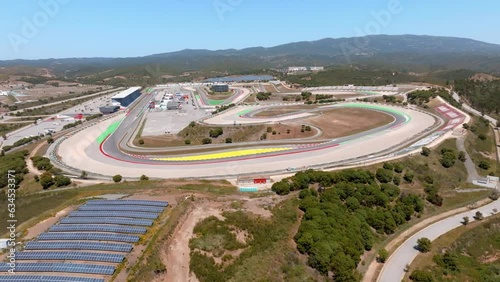 Drone pullback to sky reveals portimao circuit and red yellow lanes, blue sky day photo