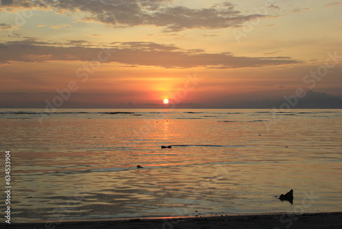 photo illustration of a beautiful view of the beach as the sun sets on the western horizon
