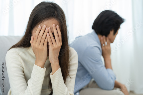 Fotografia Family problems, Asian women cover her face and sit separately from husband feel disappointed after quarrels at home