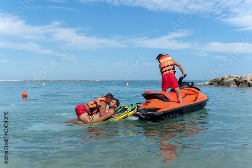 Lifeguards rescue a man in the sea using a jet ski