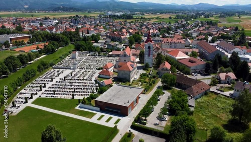 Aerial flyover church with cemetery in small Slovenian village during sunny day photo