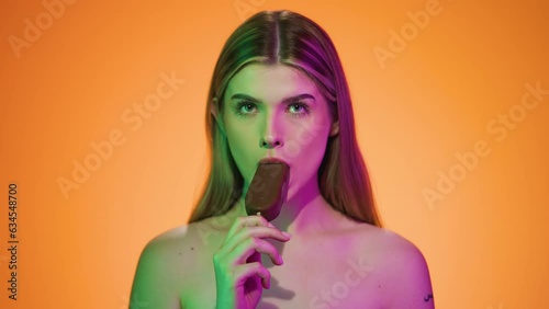 Young Sexy Caucasian Naked Blonde Lady Eats Ice Cream Chroma Background with Sensual Gesture, Portrait Shot photo