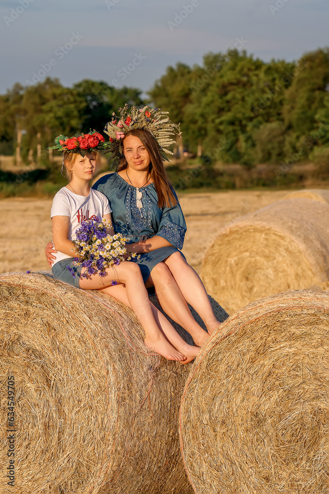 Portrait of mother and daughter in Ukrainian traditional outfits, with wreaths on her head. Portrait of mother and daughter in Ukrainian traditional outfits, with wreaths on her head.