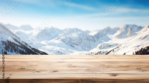 Empty wooden table top with blur background of snow capped mountains